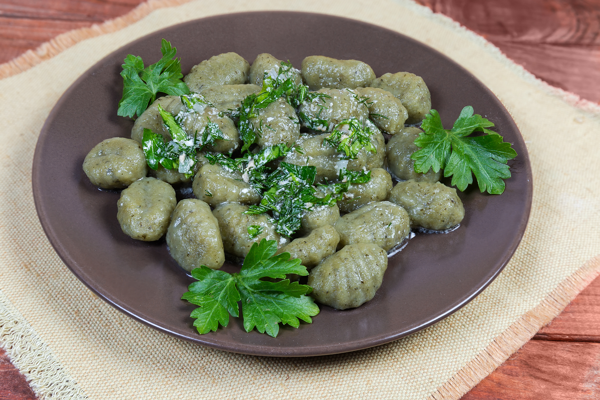 cooked potato gnocchi with spinach, seasoned white sauce, choppe