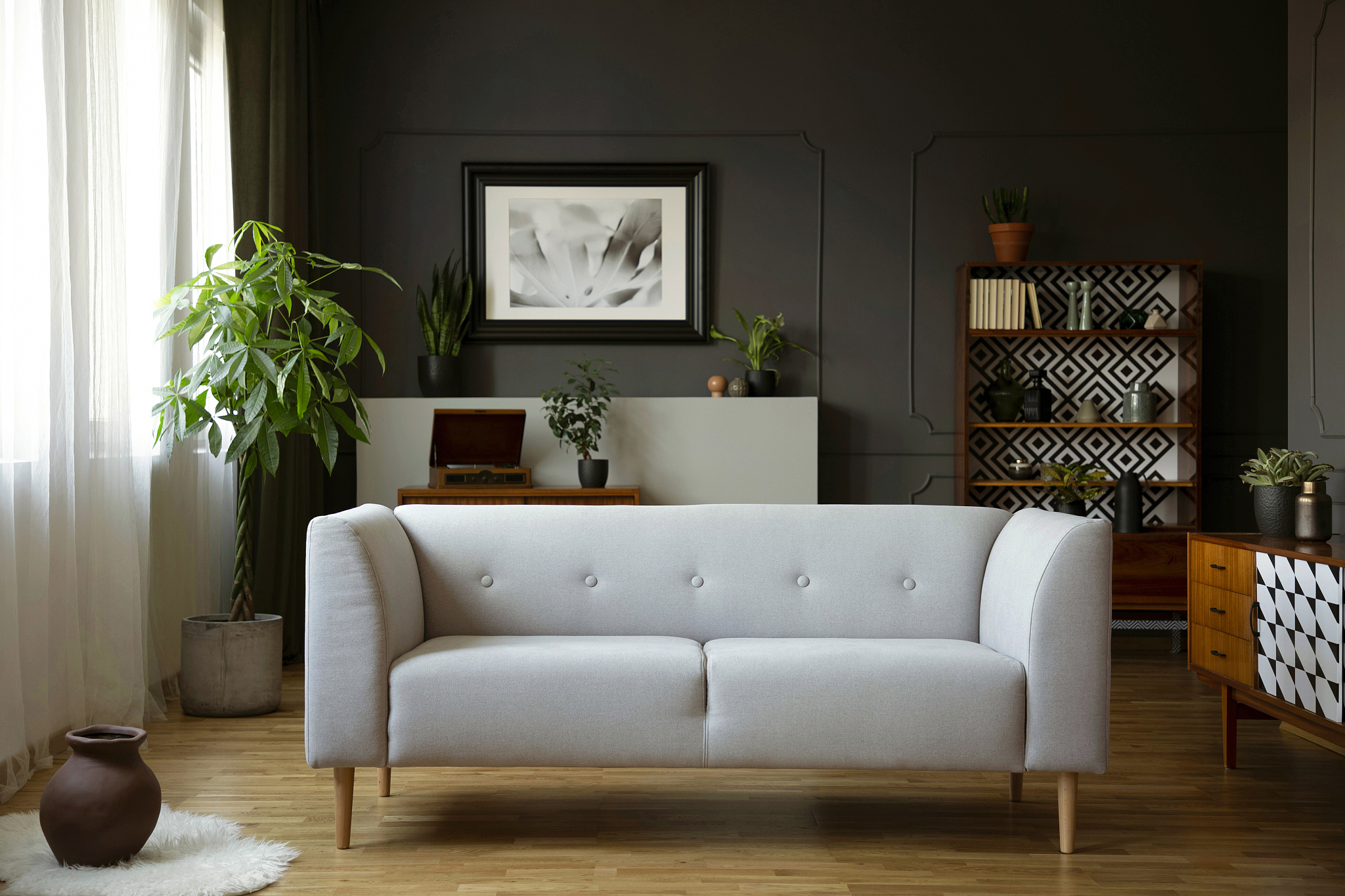 grey couch in vintage living room interior with wooden cupboard,