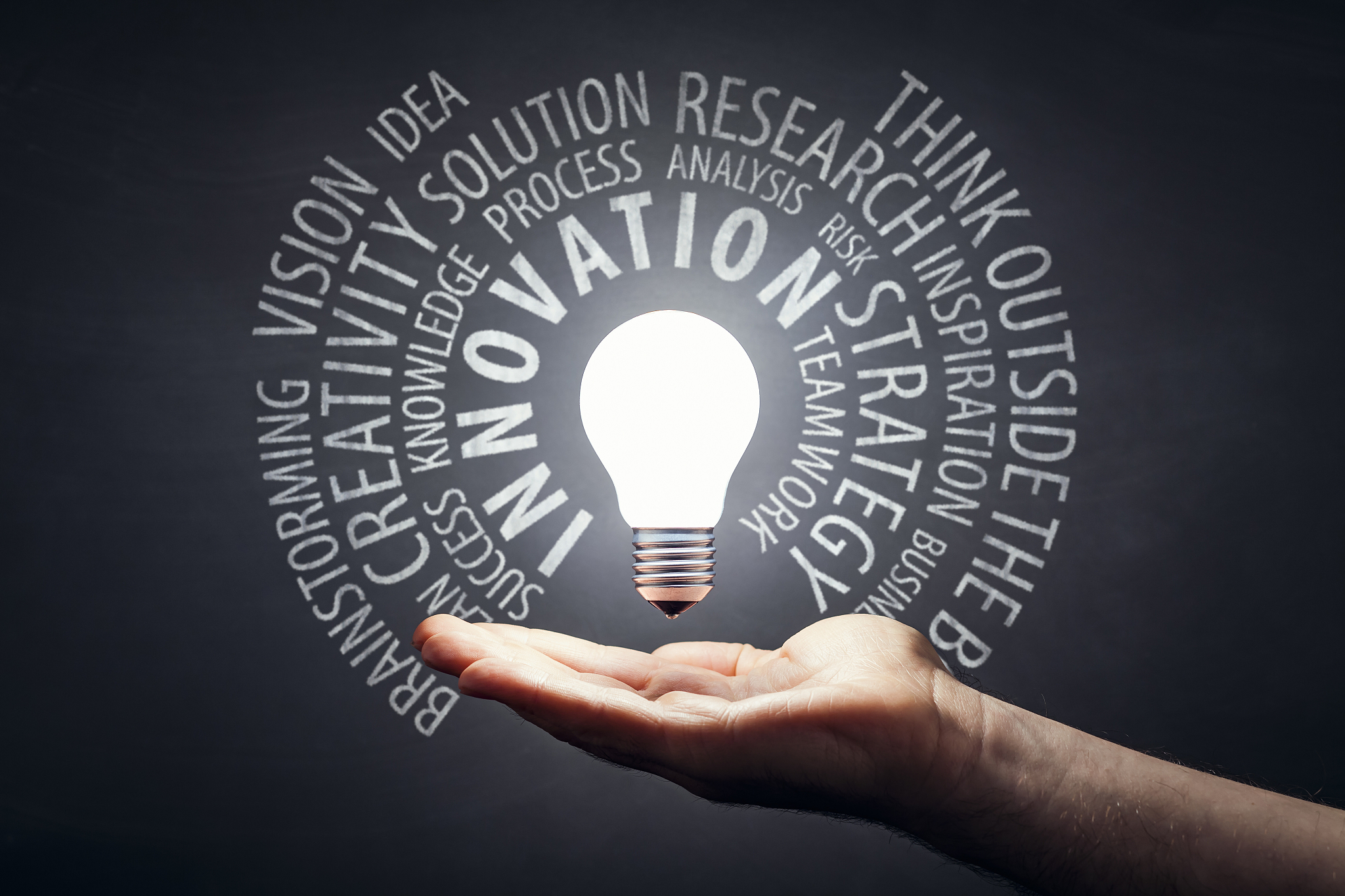innovation - light bulb hand idea blackboard