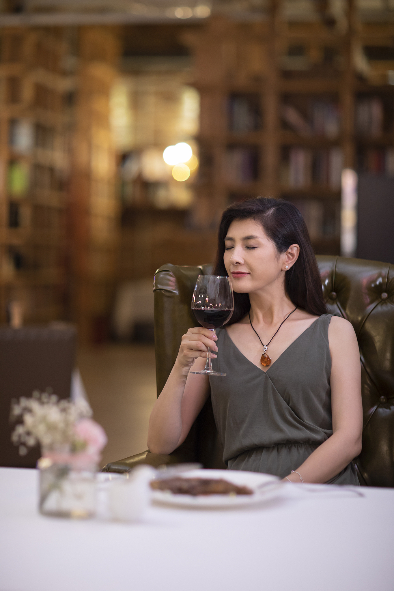 优雅女士在餐厅品尝红酒
