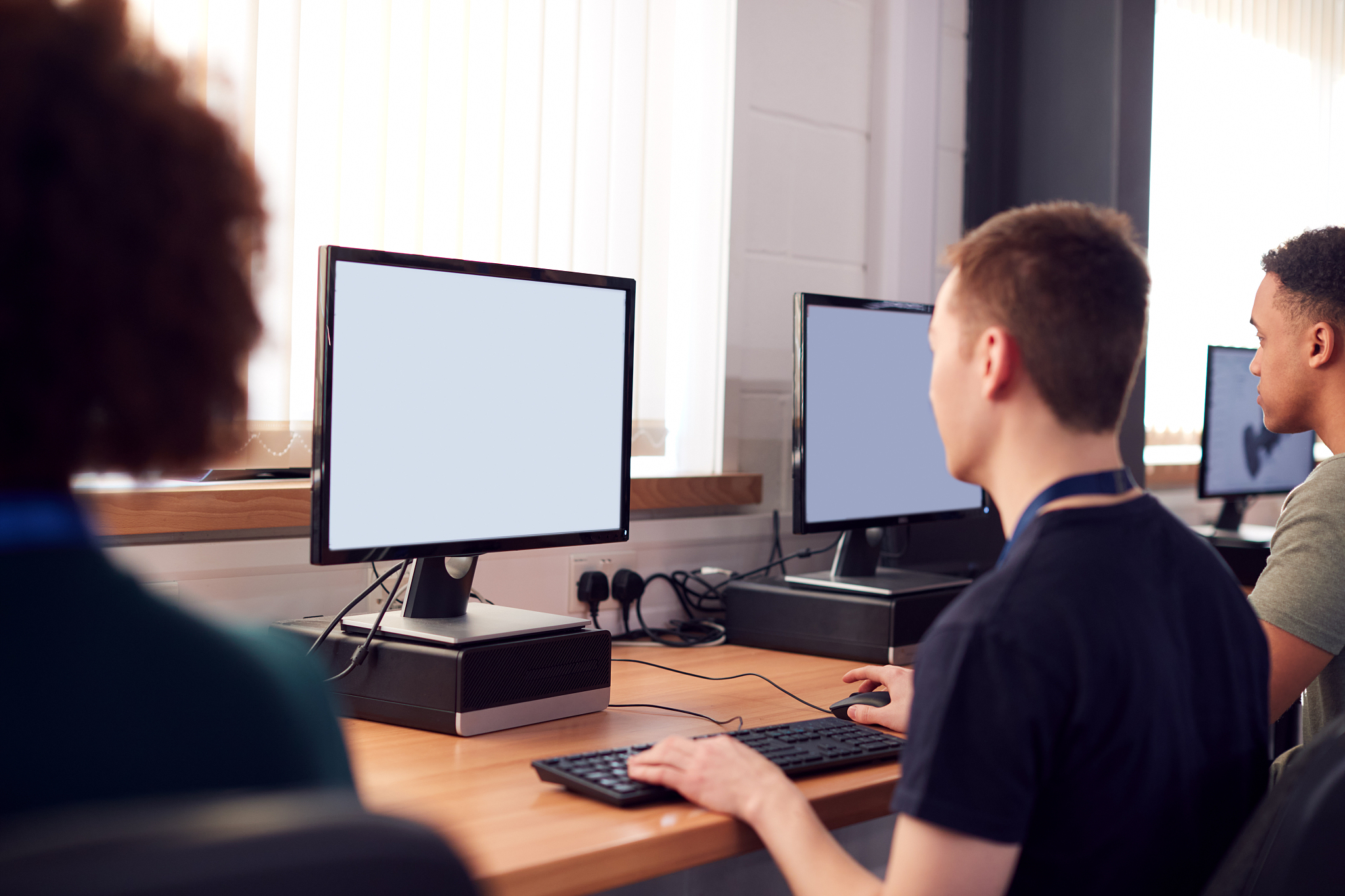 group of college students studying computer design sitting at li