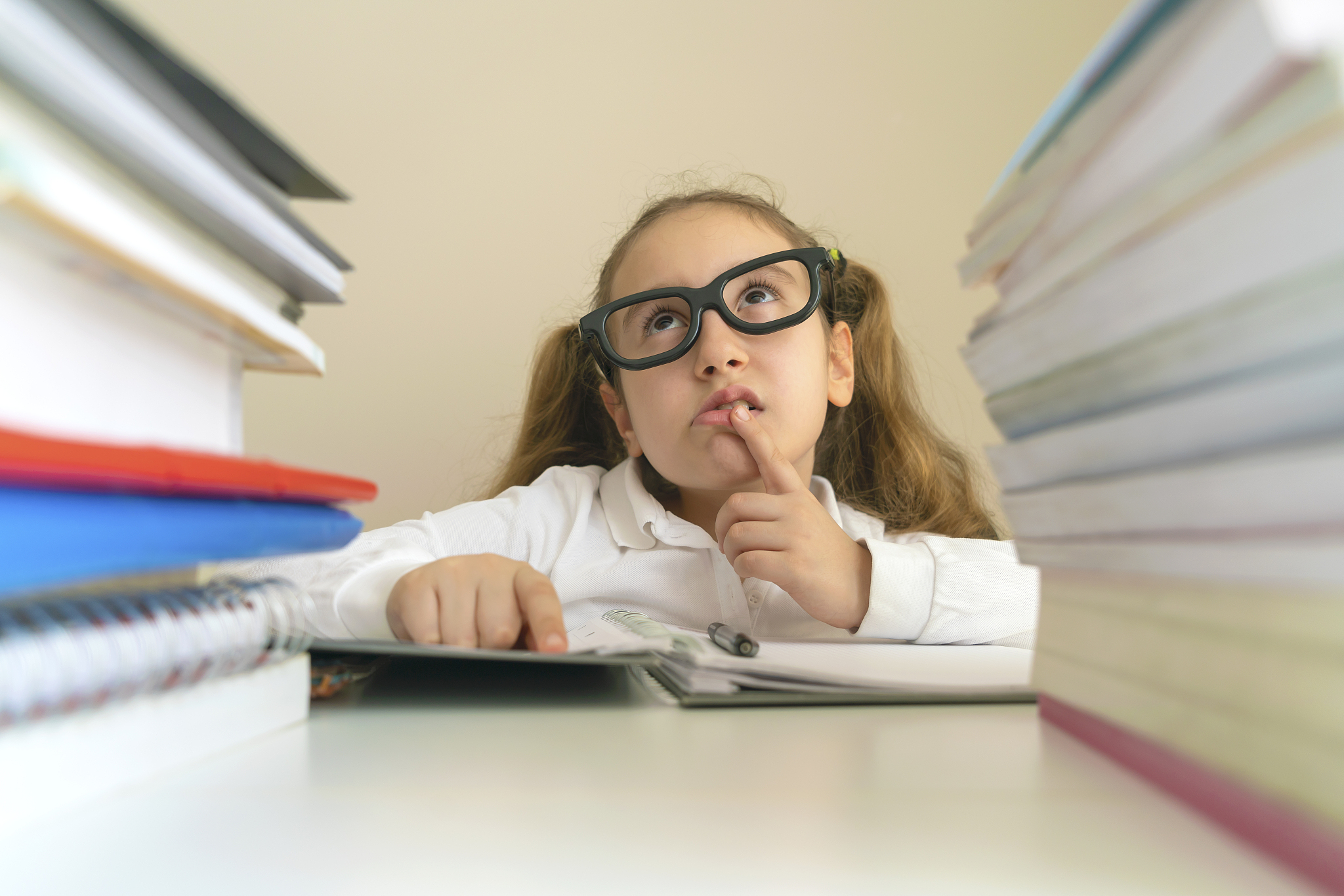 the schoolgirl doing homework at the desk with books