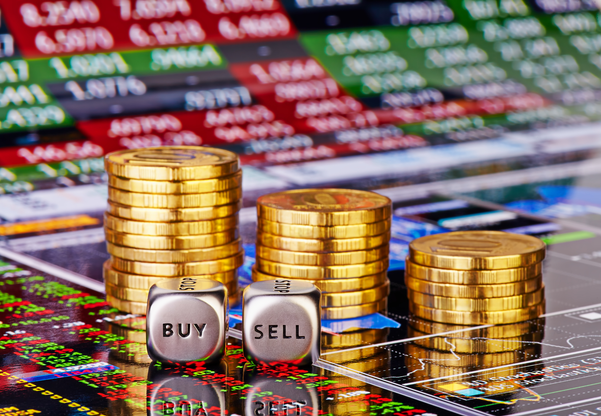 stacks of coins, dices cubes with the words sell buy