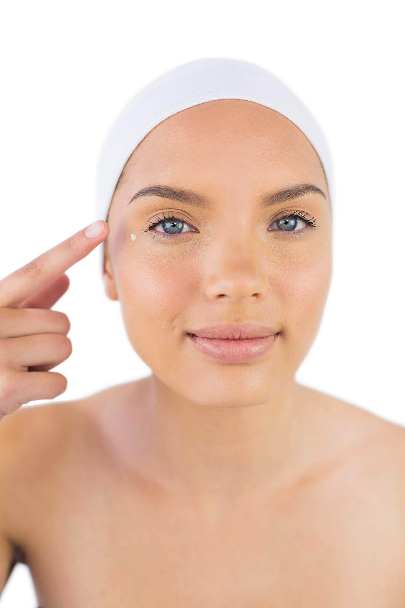 attractive woman weaing headband putting cream on her face