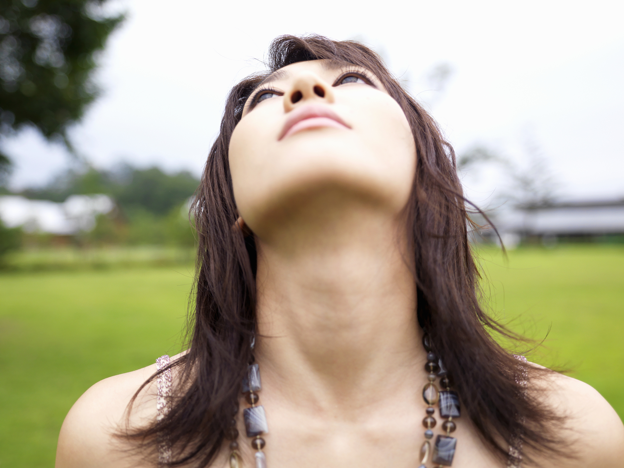 young woman looking up outdoors, close-up