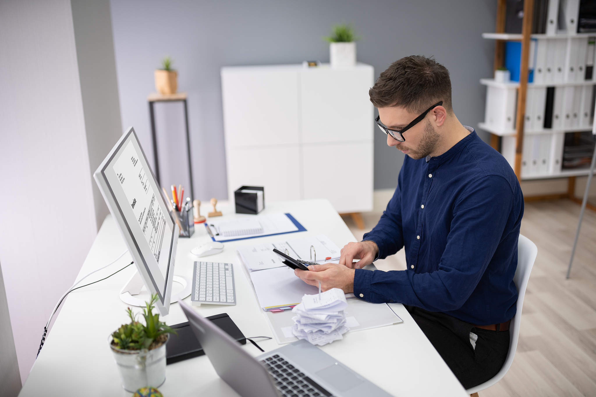 businessman calculating invoice in office