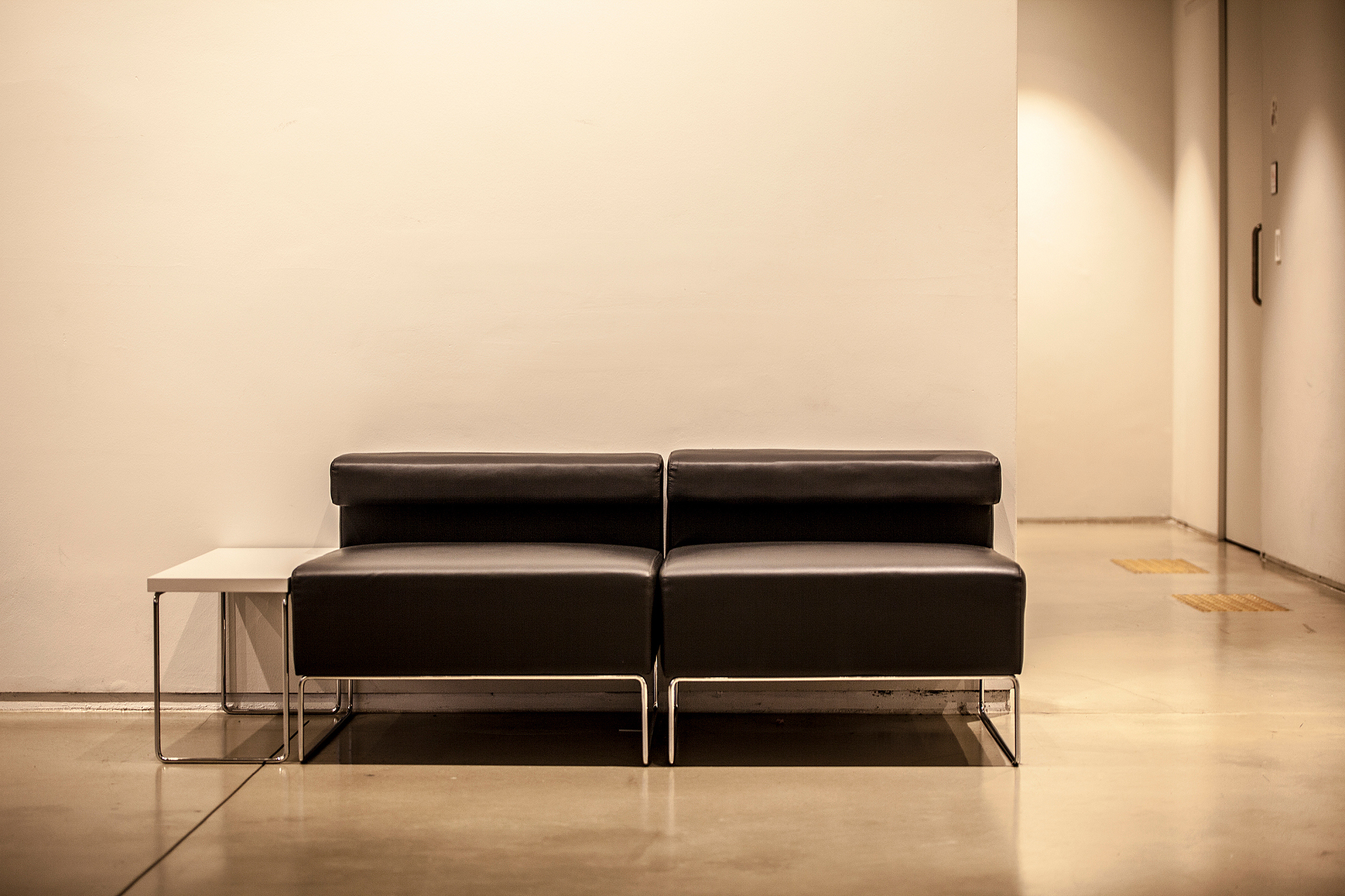 empty black seats by wall in illuminated room