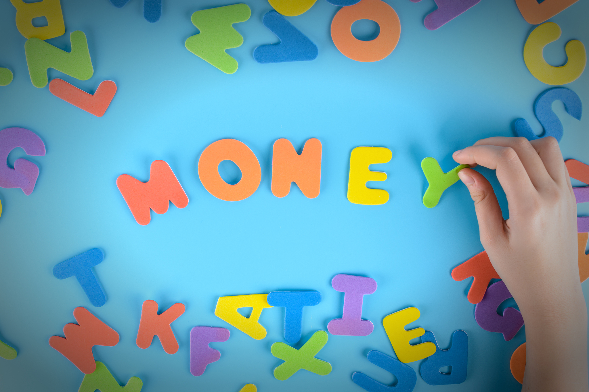 the girl puts the word money out of colorful letters. beautiful 