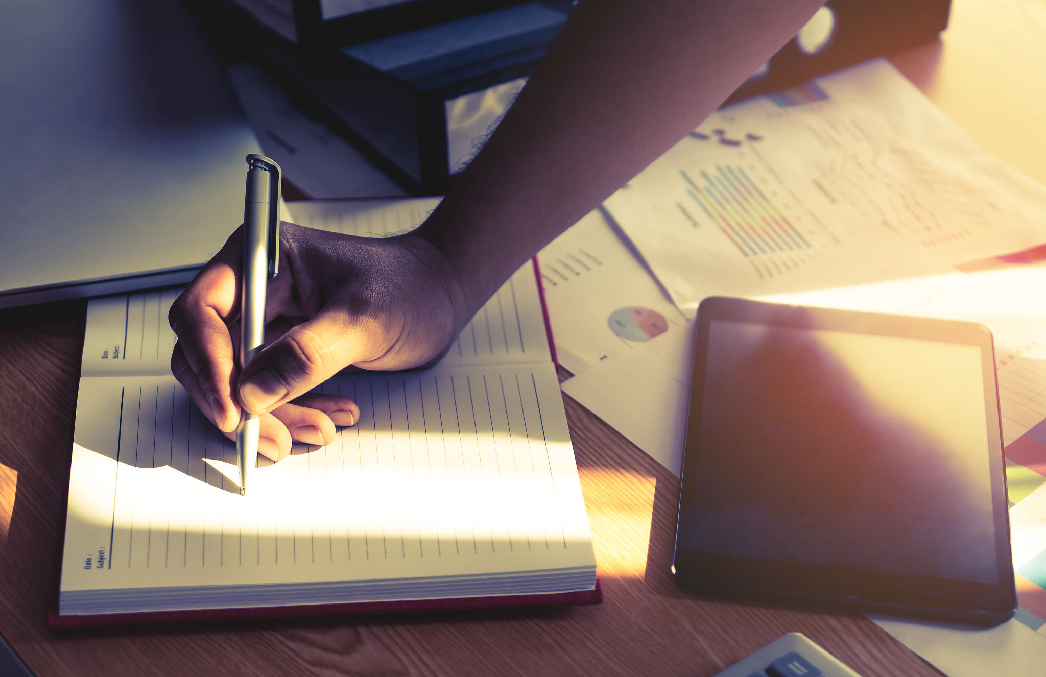creative business start up owner hand writing on to a notebook