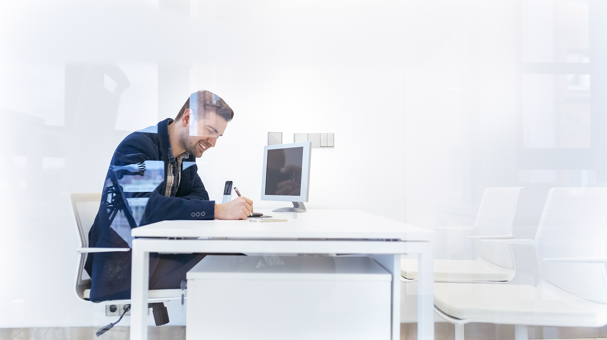 smiling young man working at desk in office