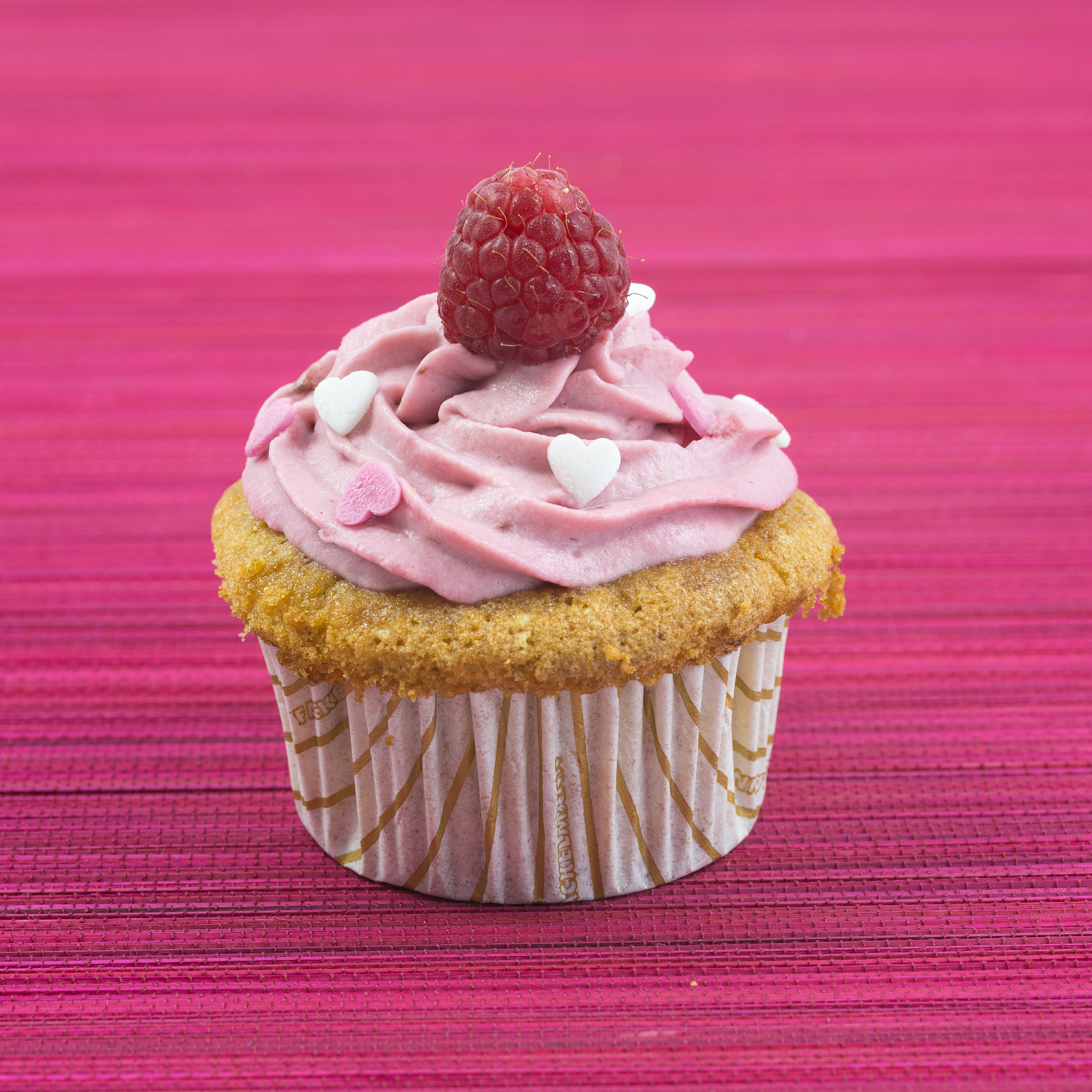 pink cupcake with raspberry on top