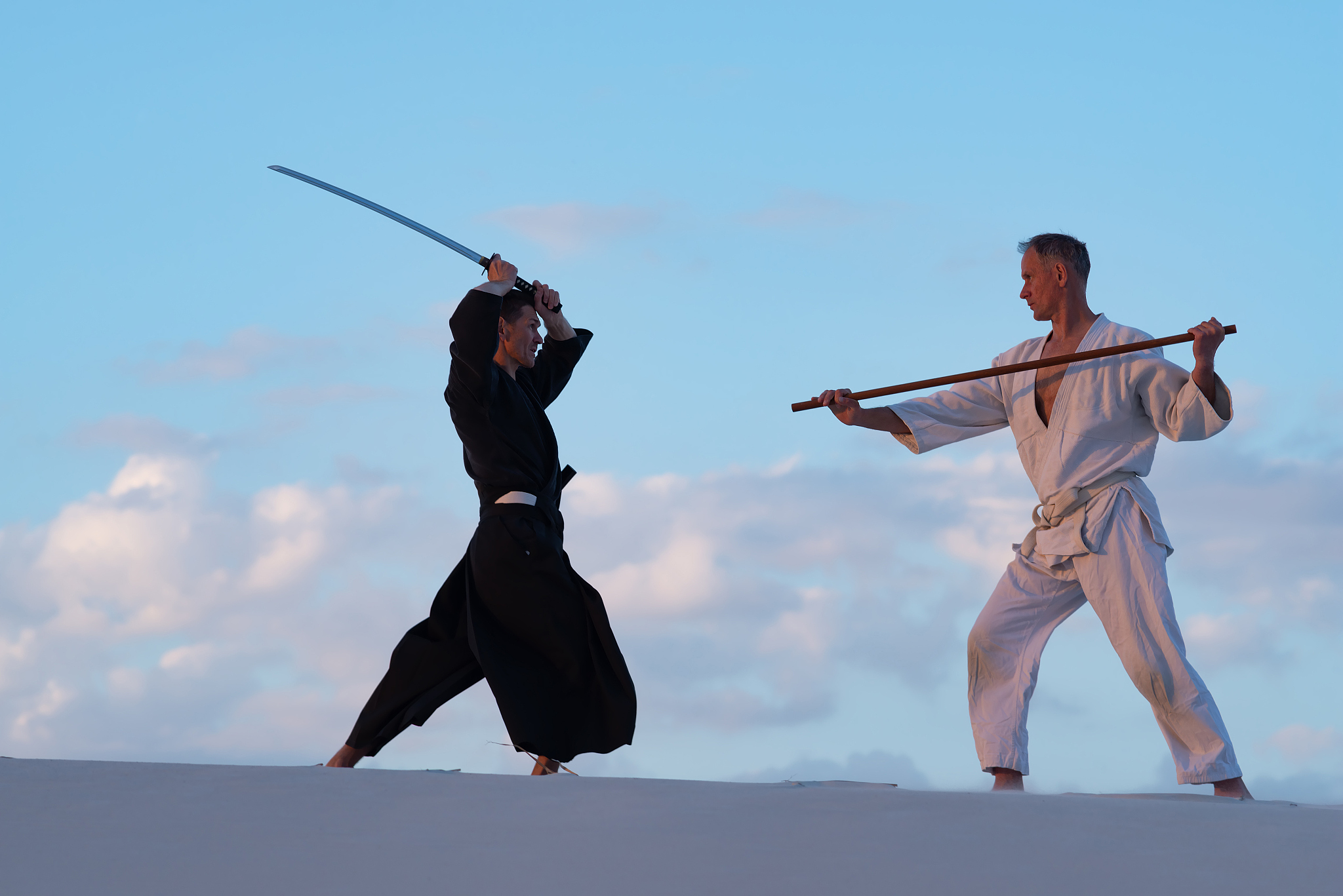 men are practicing martial arts with a traditional japanese weap