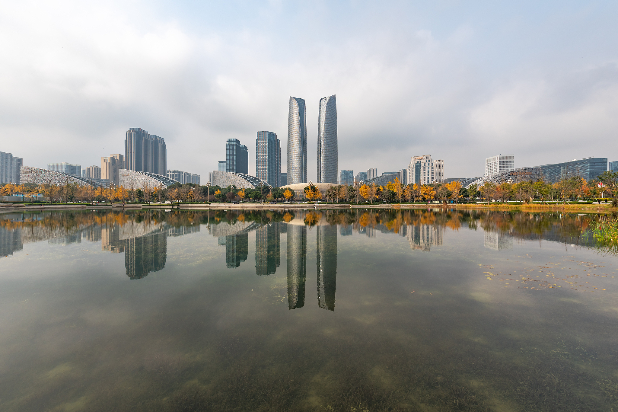 skyscrapers reflecting in a lake in chengdu