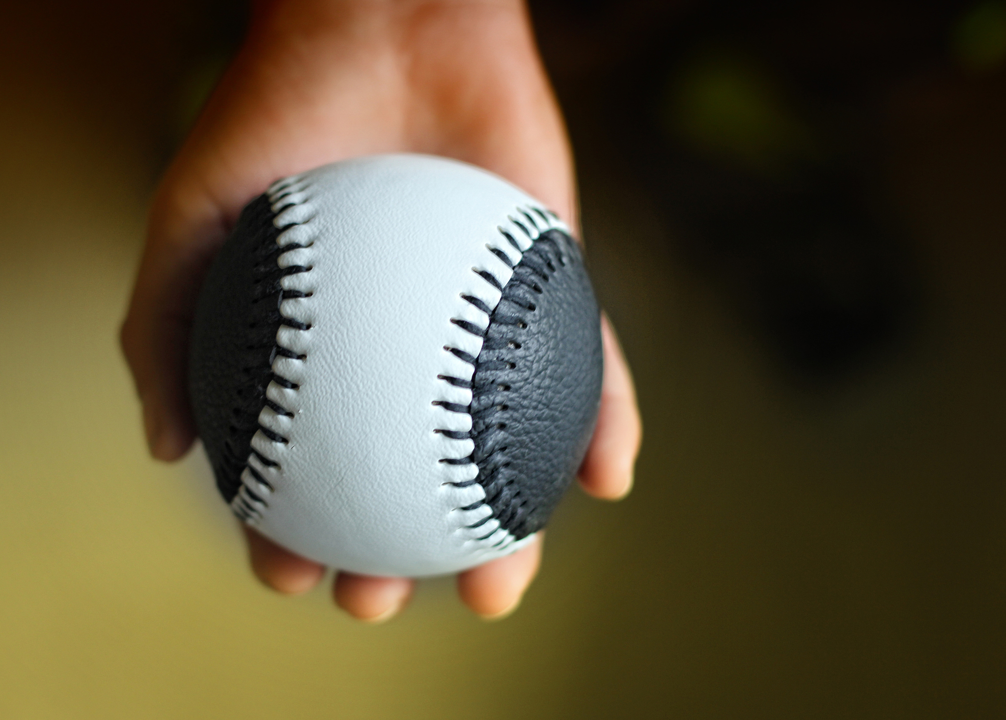childs hand holding new baseball