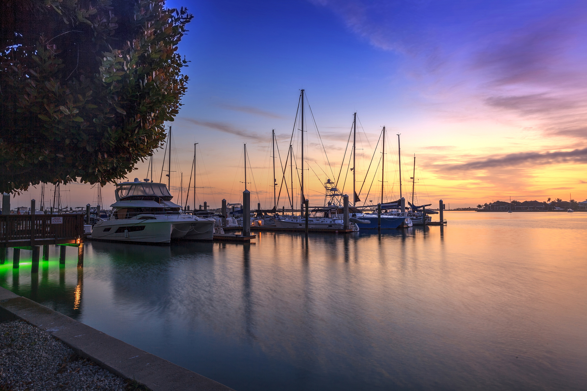 break of dawn sunrise over boats and sailboats at factory bay ma