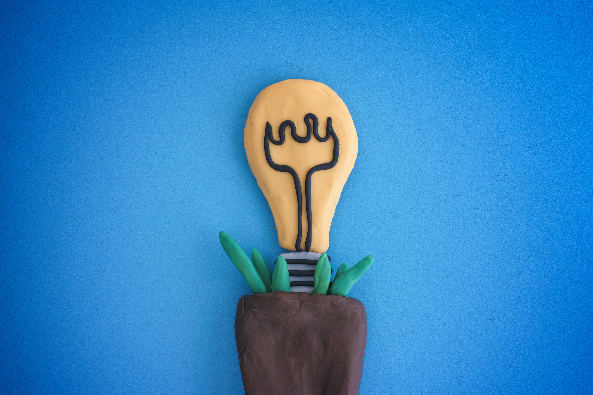 ligh bulb growing in a plant pot. light bulb and pot are made ou