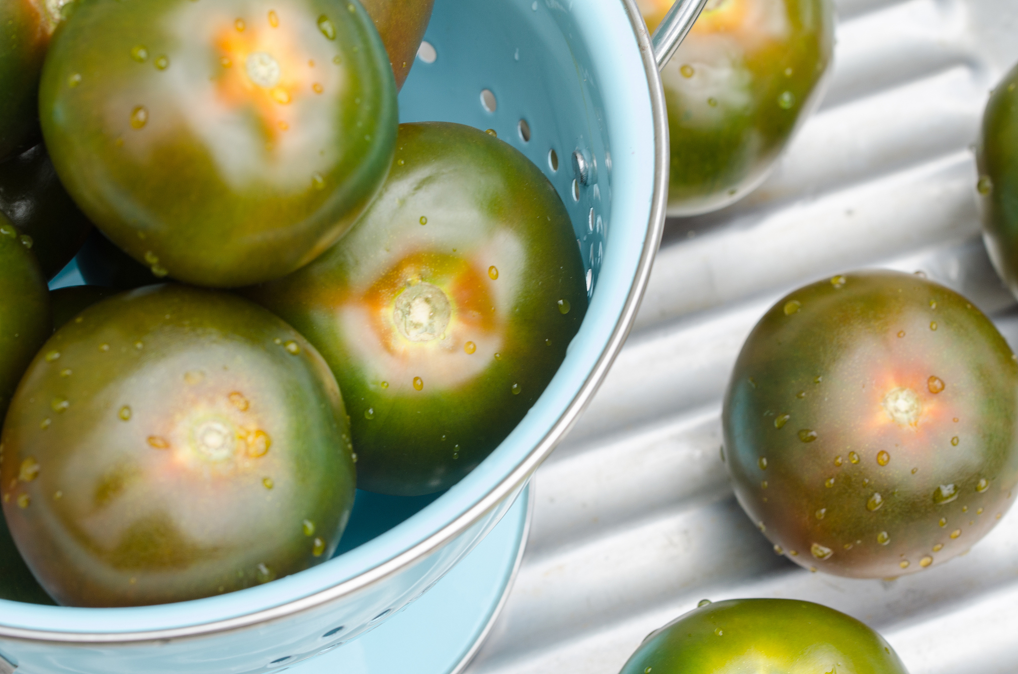 close-up of unripe tomatoes in colander on table