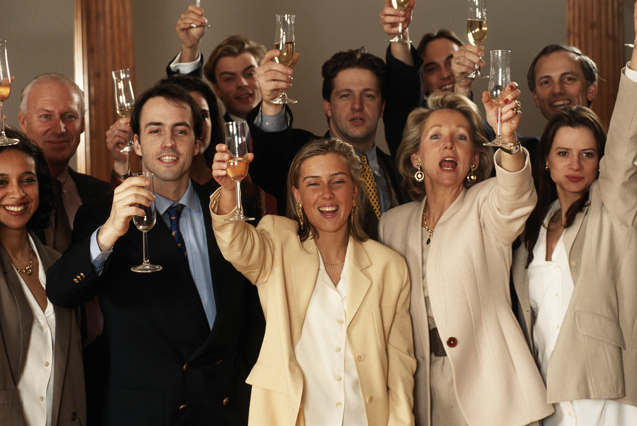 business people raising glasses, smiling
