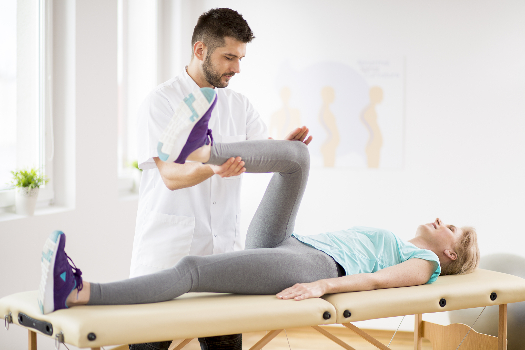 middle age woman with knee injury lying on physiotherapy table d