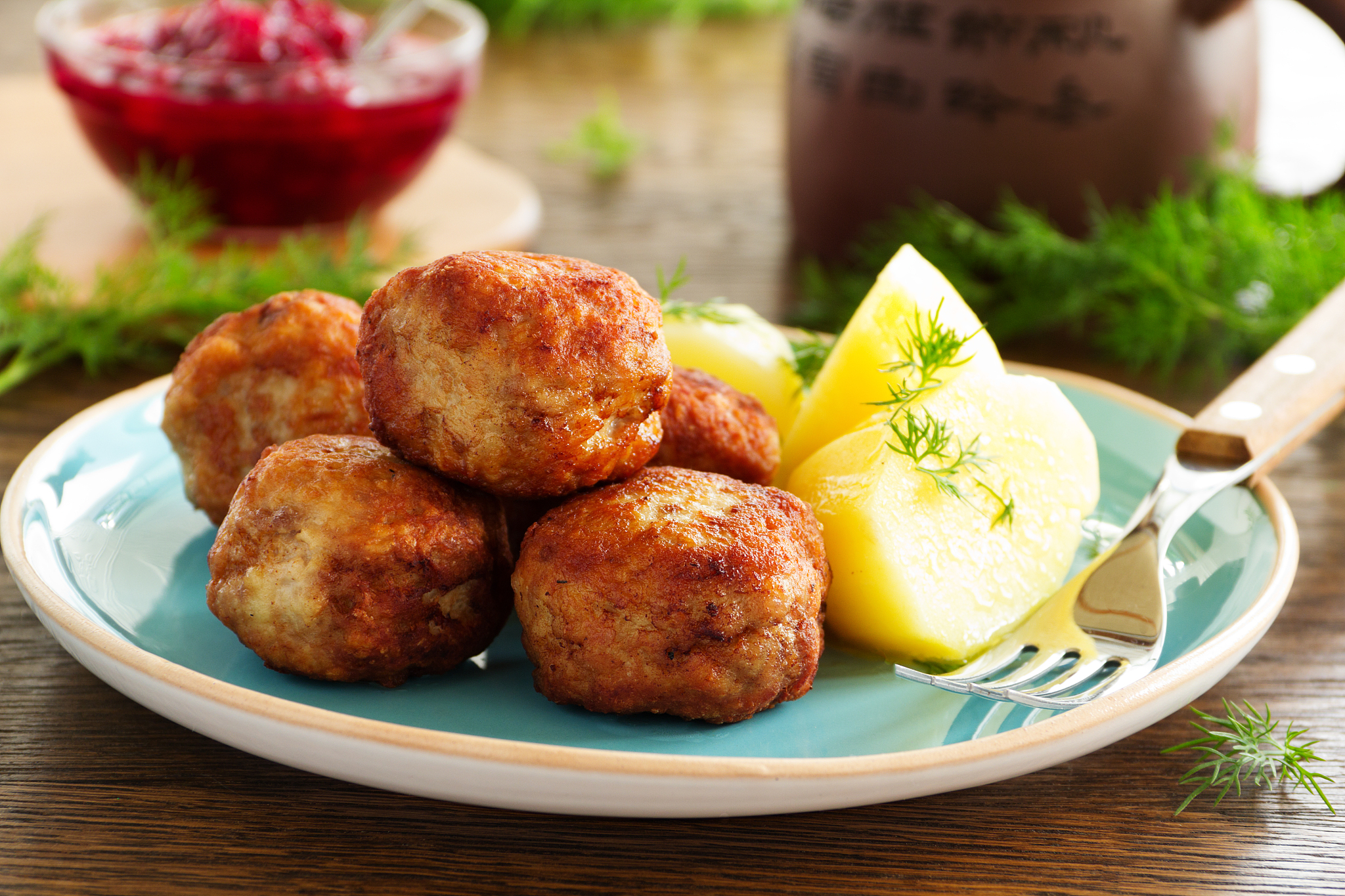 hot meatballs with boiled potatoes and cranberry sauce ..