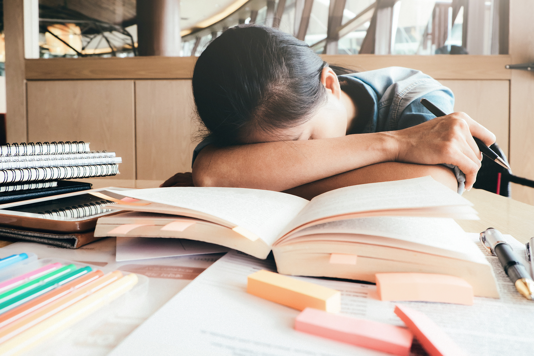 girl hard reading and sleeping in the library.