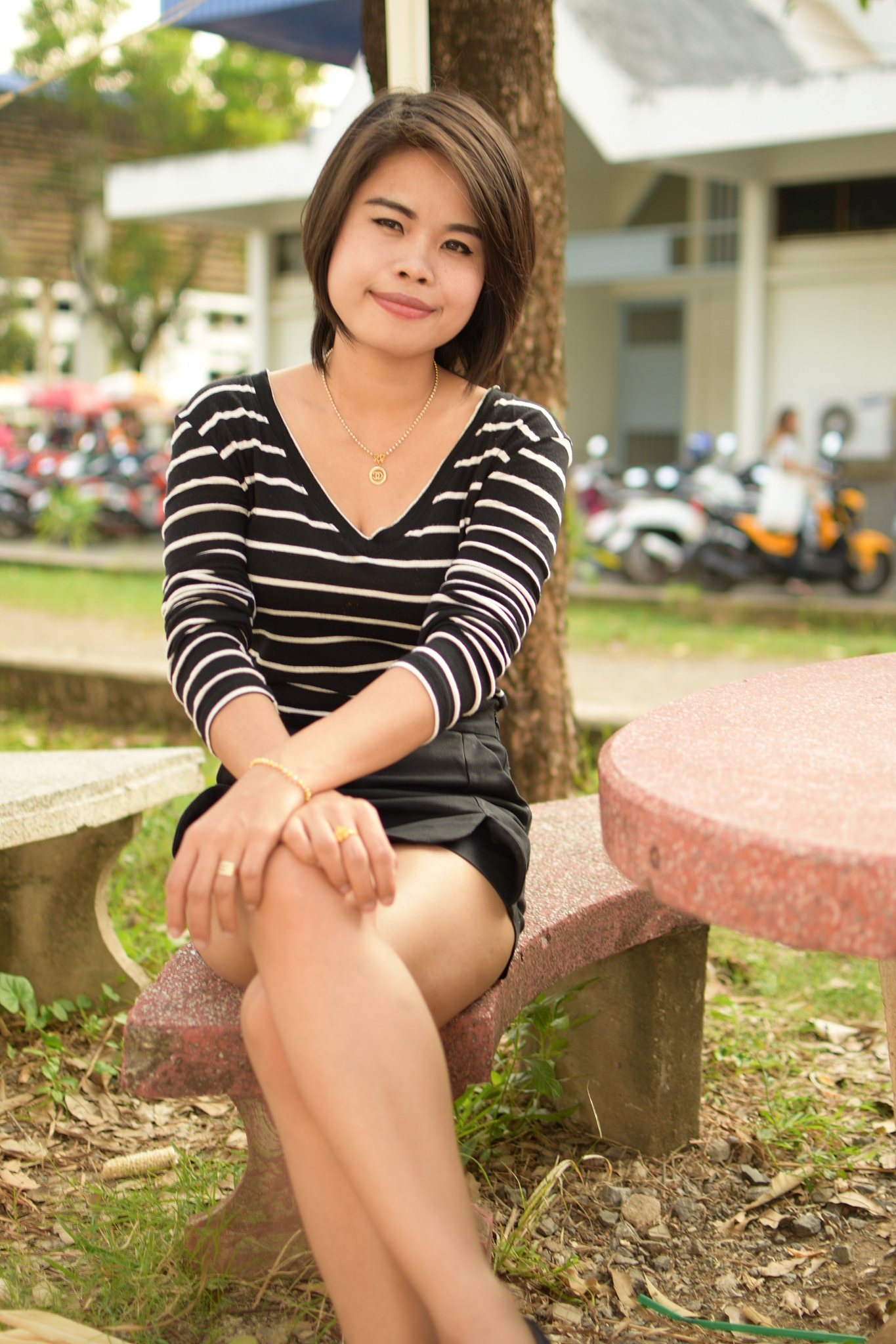 portrait of beautiful young woman sitting on bench in park