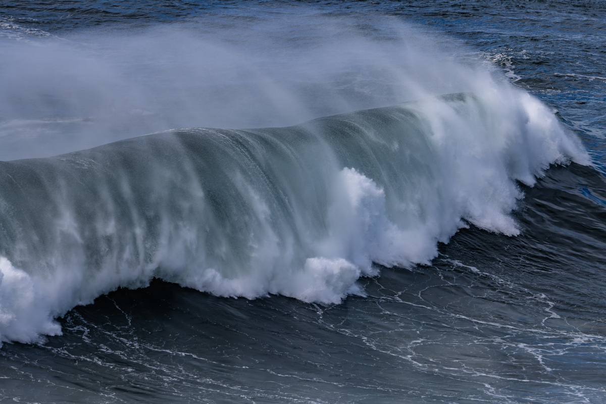 请描述一段海浪加速冲向小船的画面