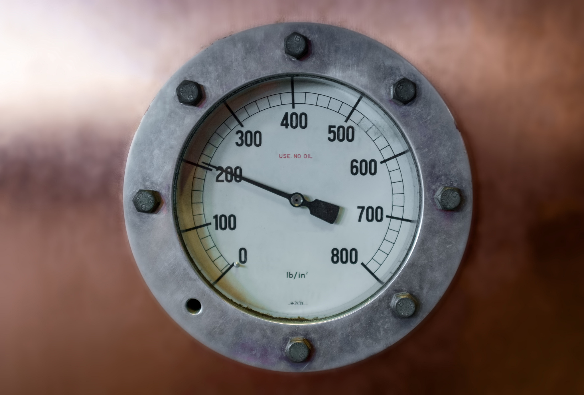 vintage pressure gauge on blurred background with arrow pointing