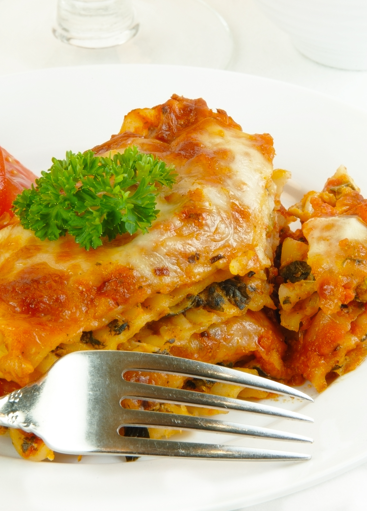 lasagna with fork on white
