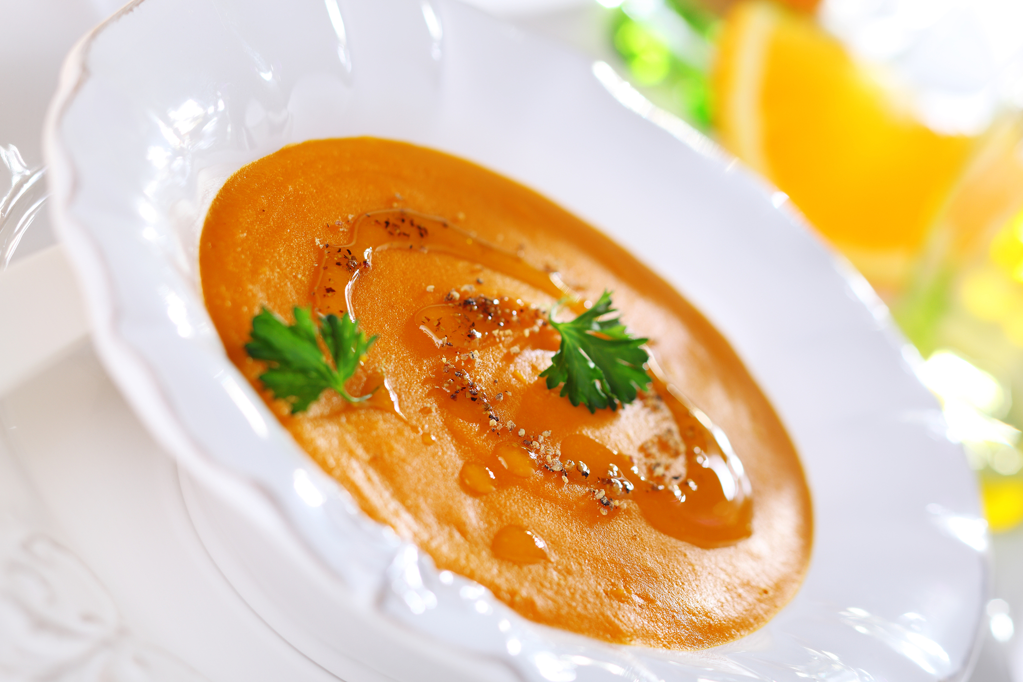 pumpkin soup with orange juice in white plate, soft focus.