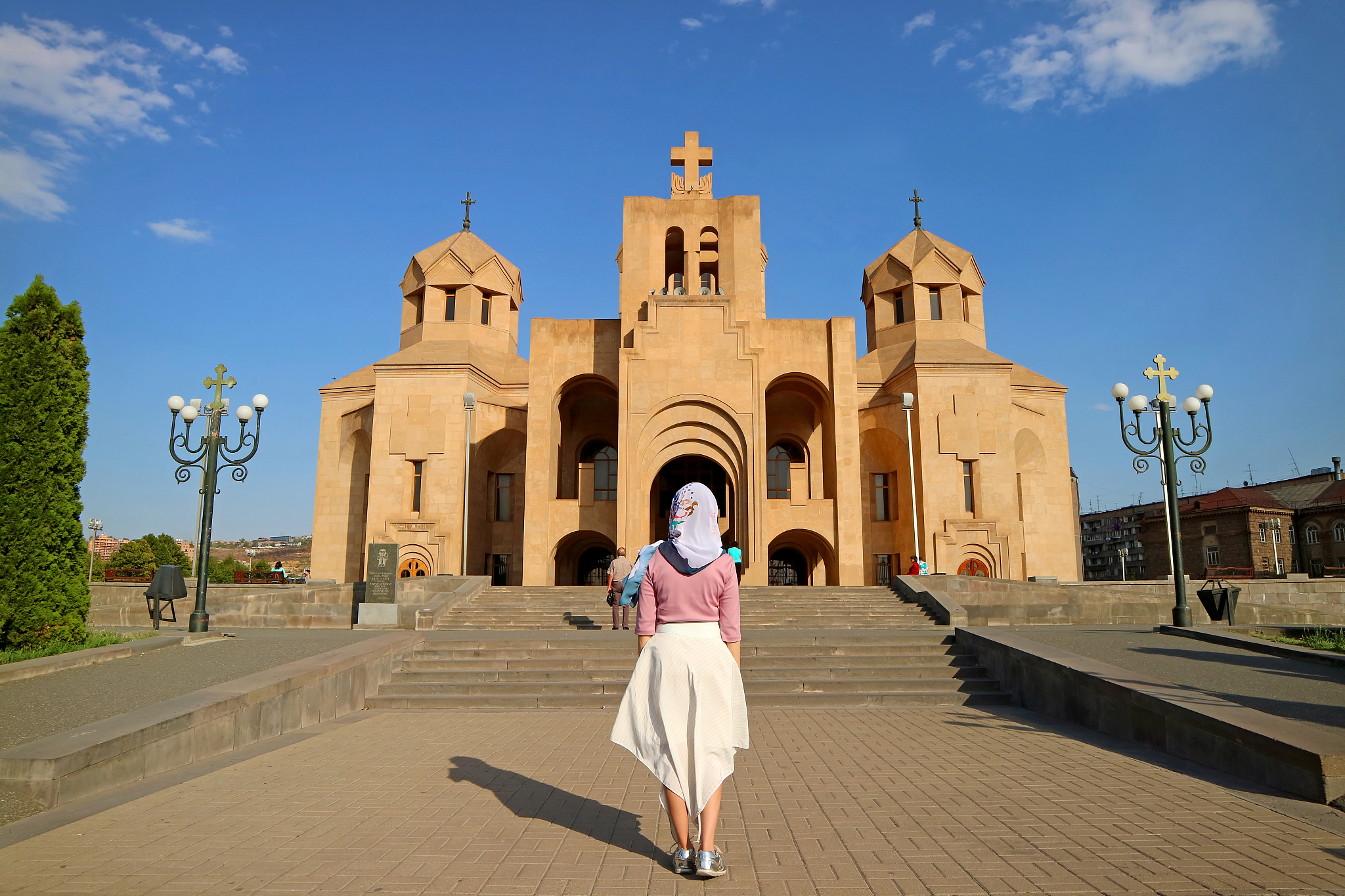 woman in white headdress in front of yerevan cathedral, located 