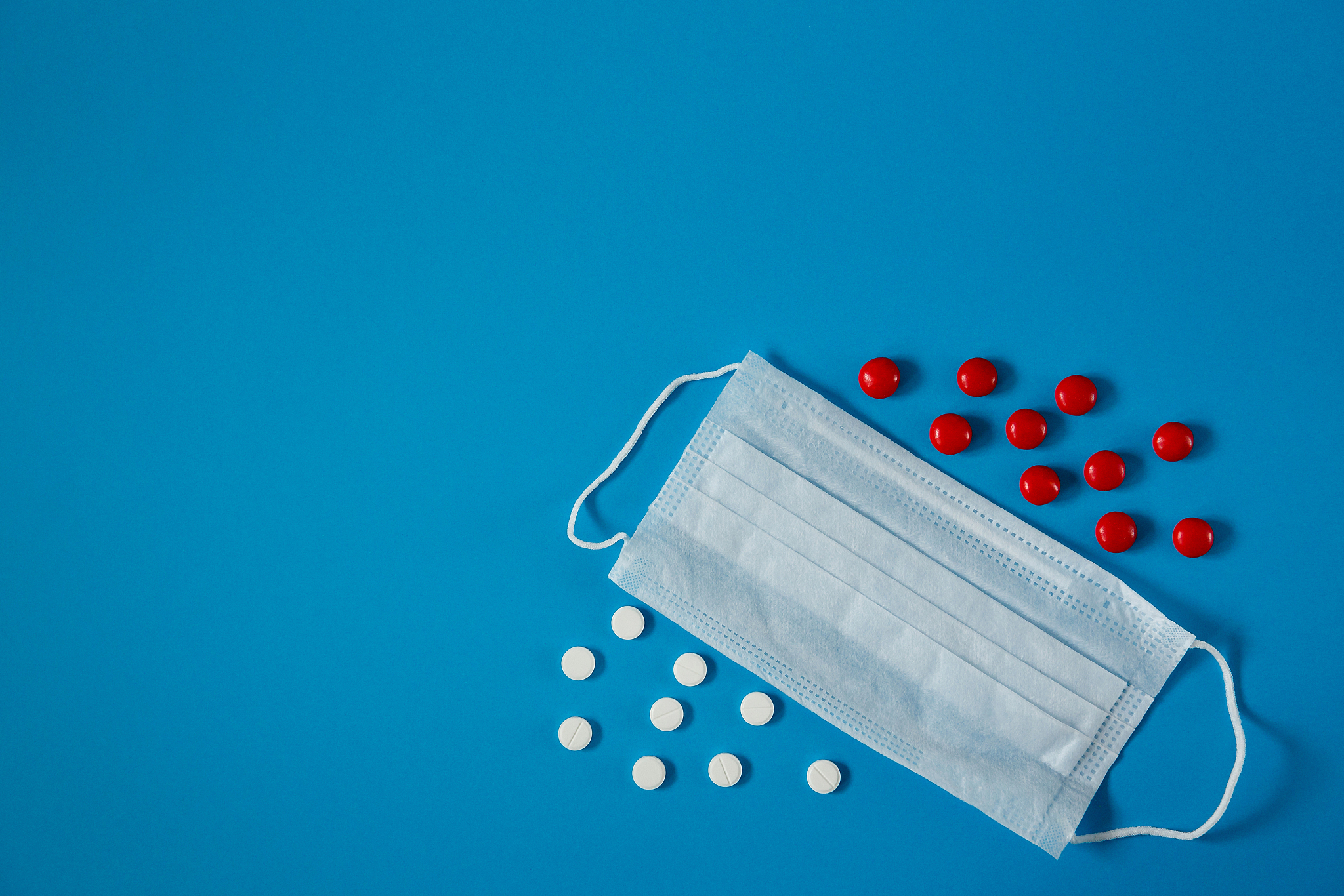 medical face mask and pills, on blue background
