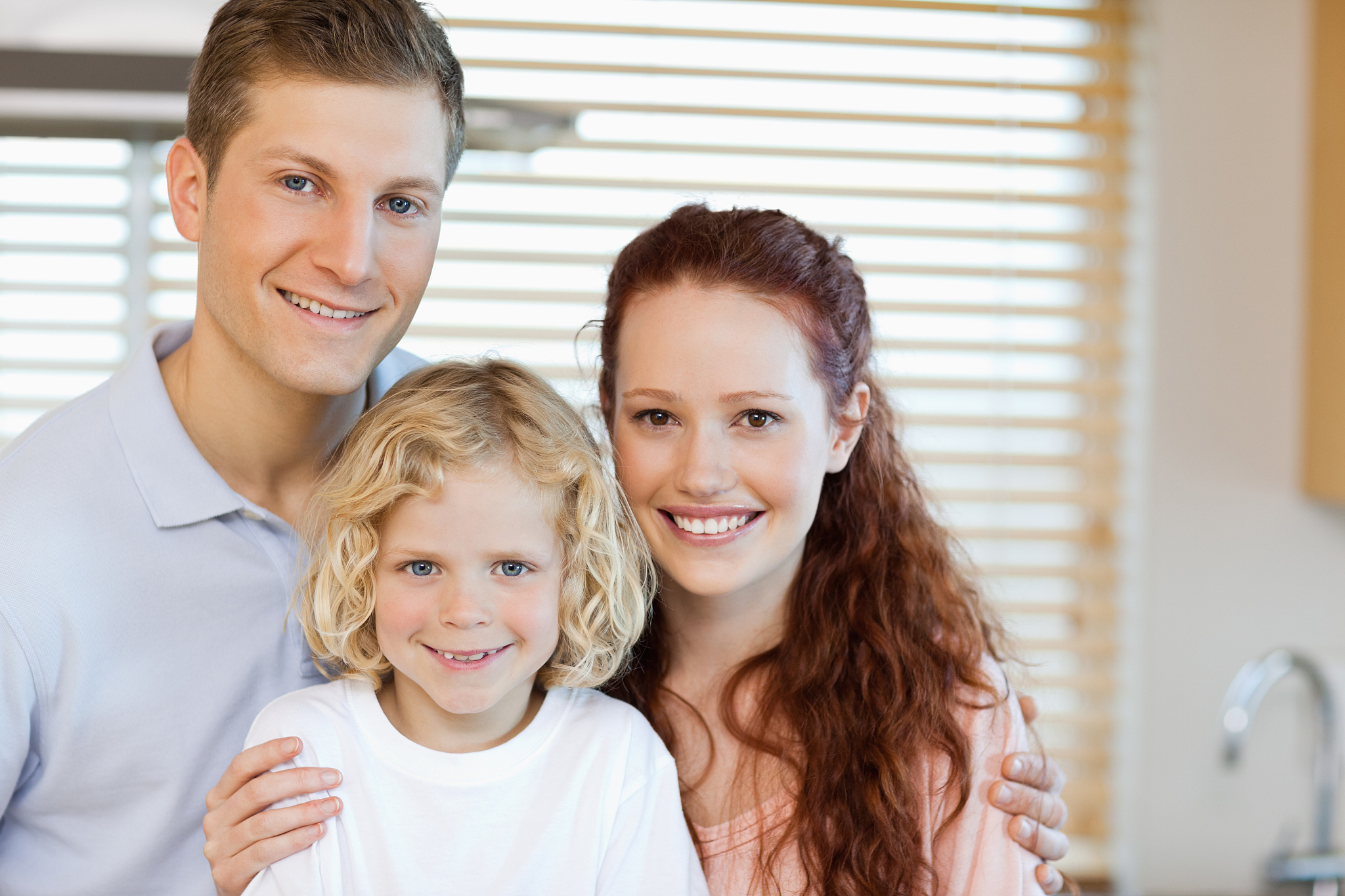 cheerful family standing in the kitchen