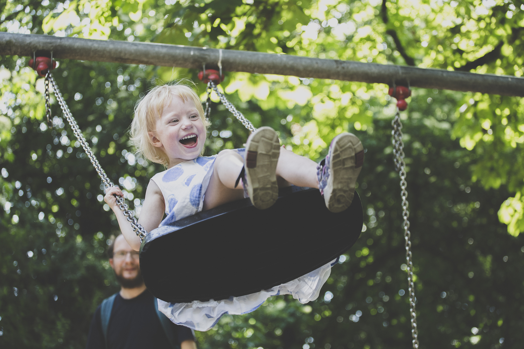 portrait of happy ltiitle girl on a swing