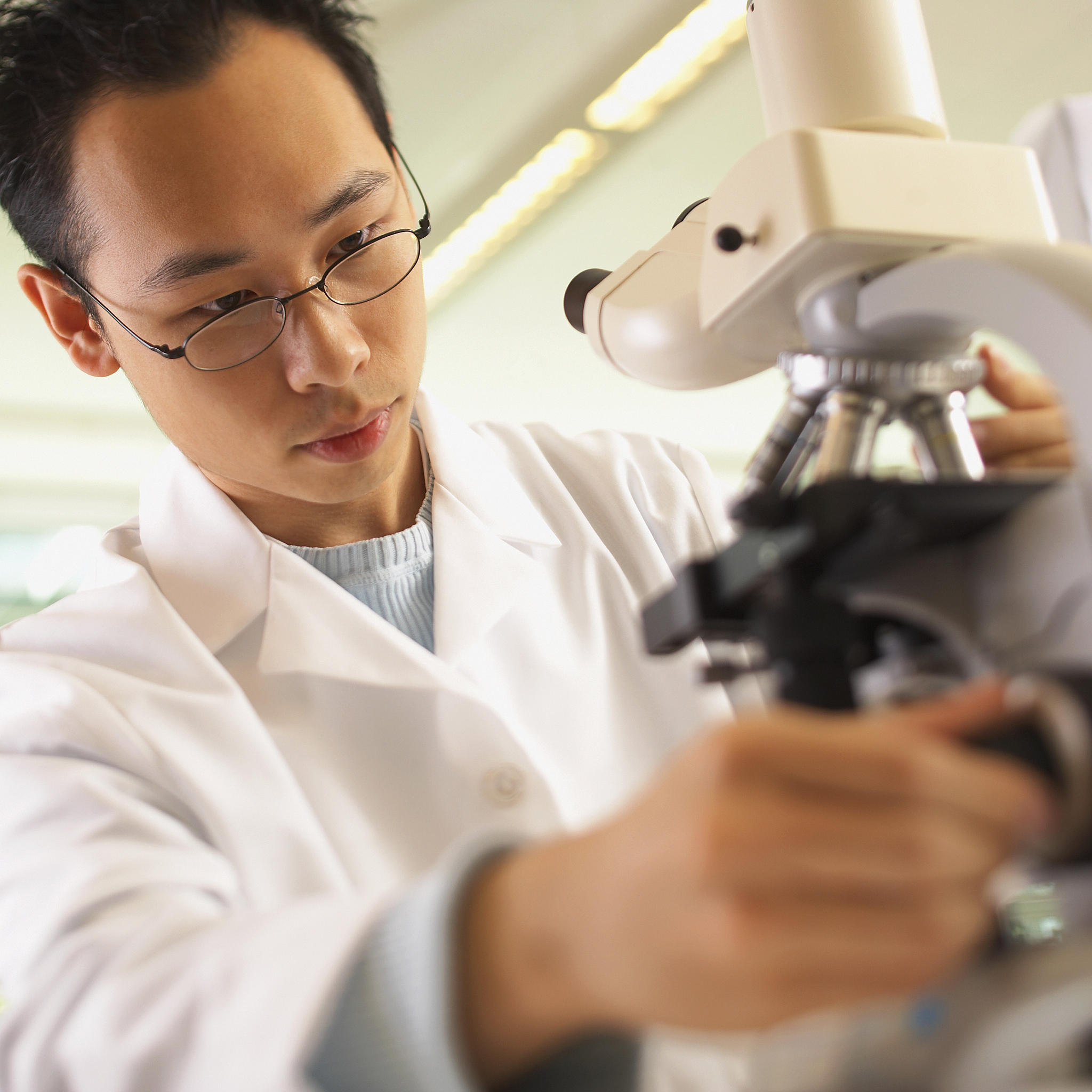 请描写一下一位带着细丝眼镜的年轻科学家的外貌