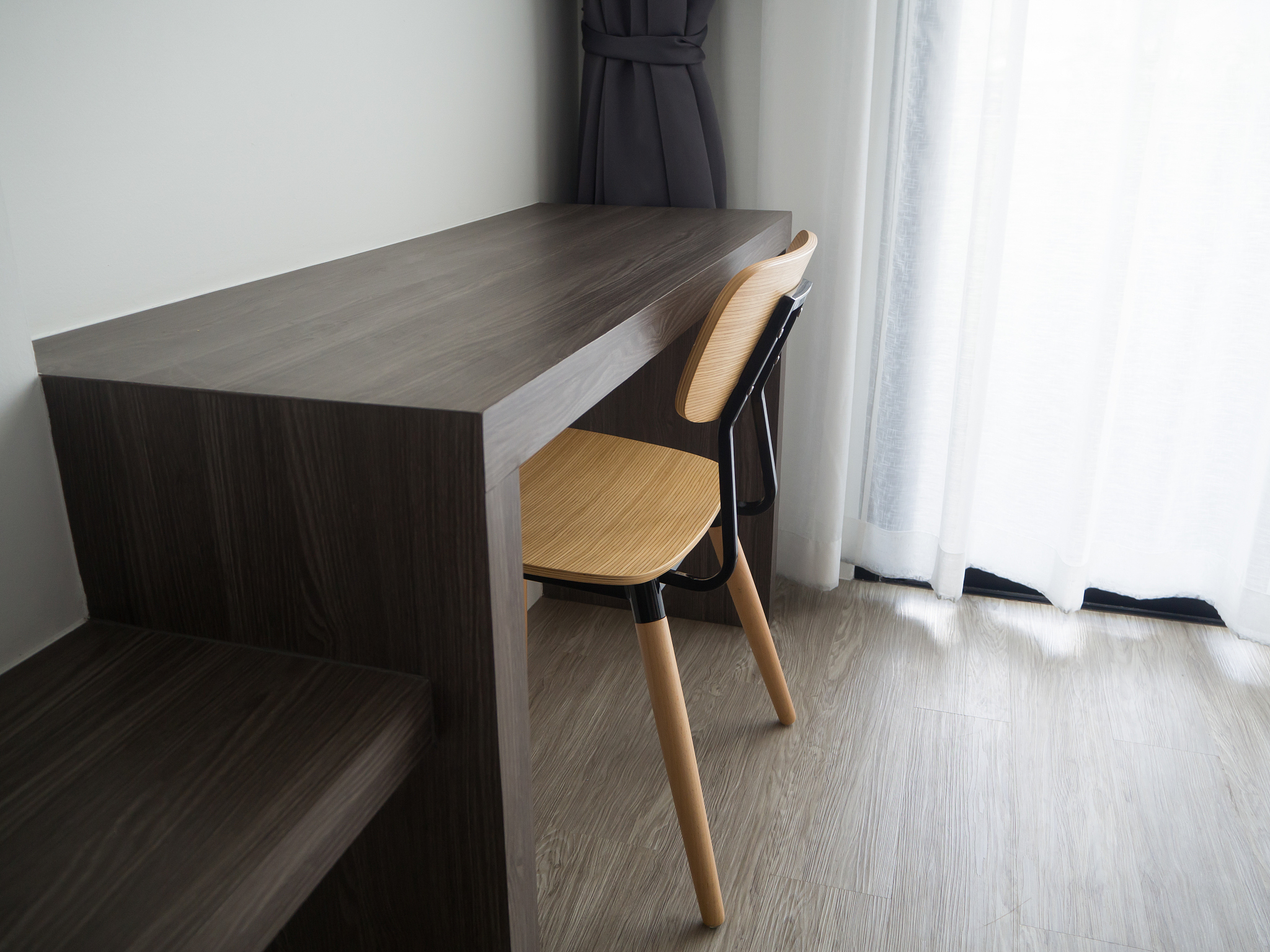 wooden office table with modern chair and blurry beautiful white