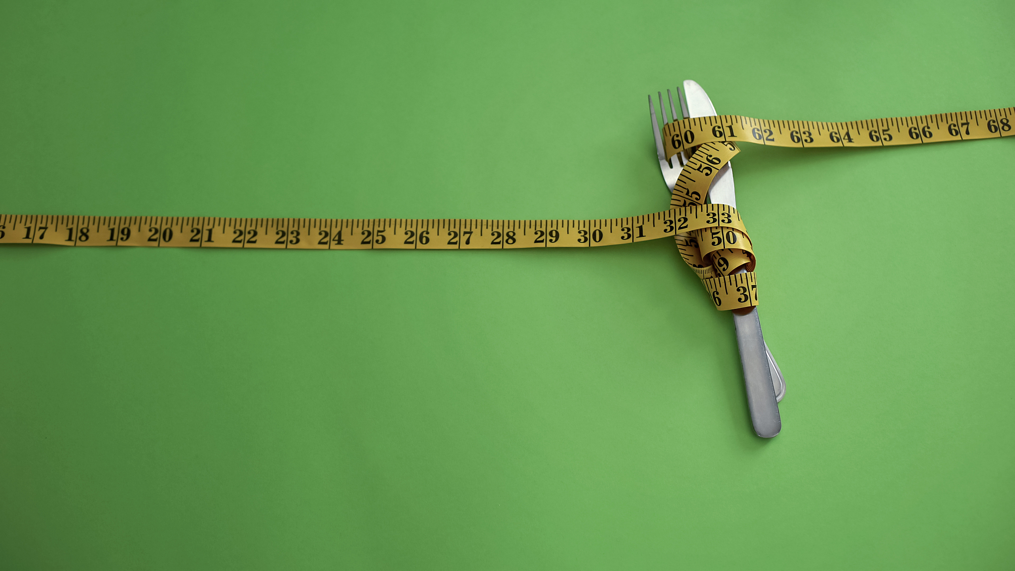 knife and fork tied with measuring tape, concept of strict food 