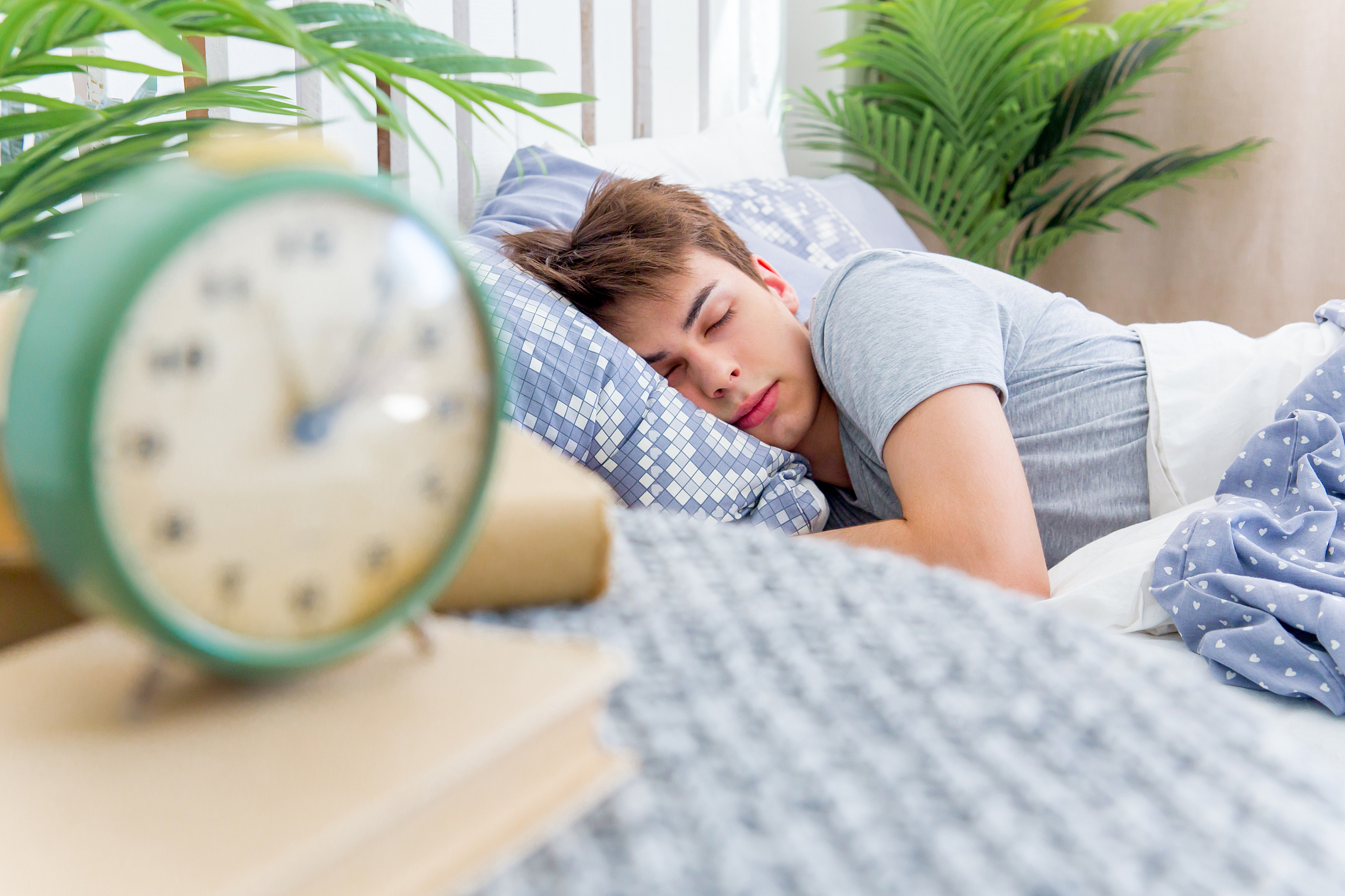 handsome young man sleeping in white bedding