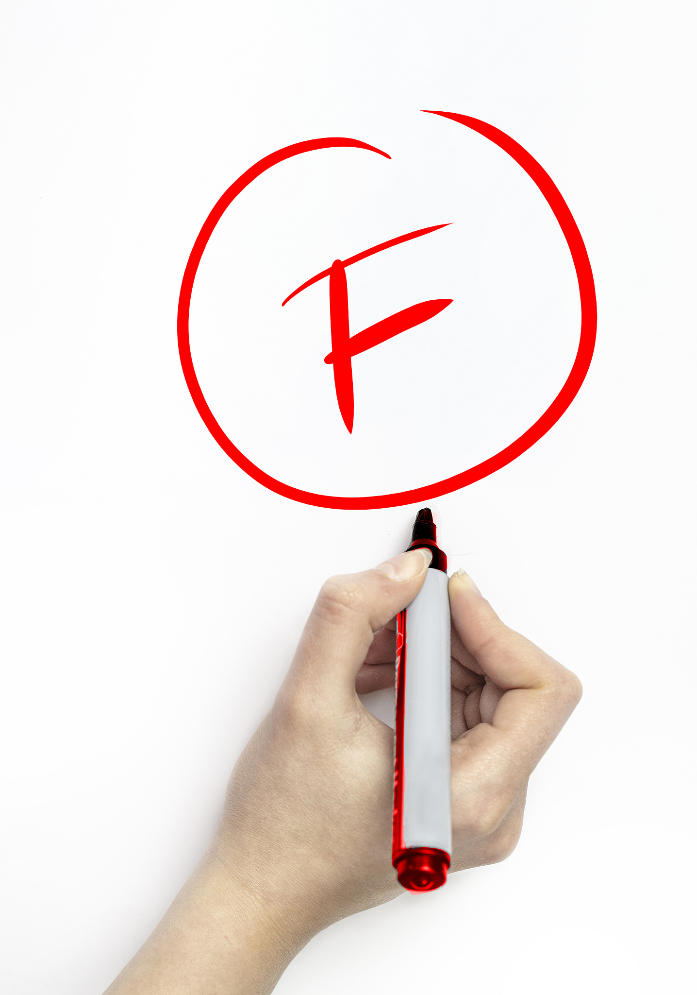 hand grading a student with red marker on white page