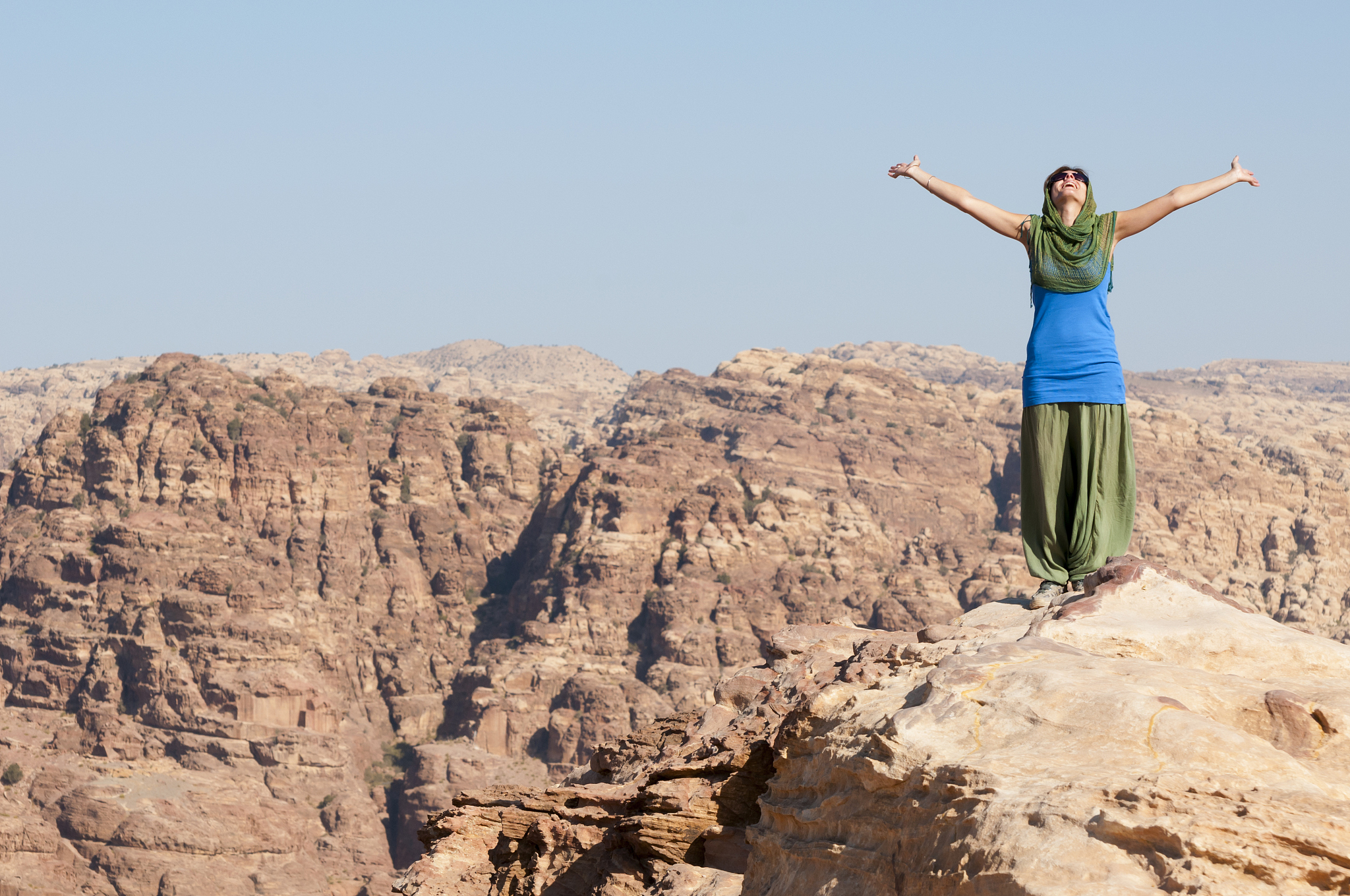 woman with arms outstretched on mountaintop (petra, jordan)