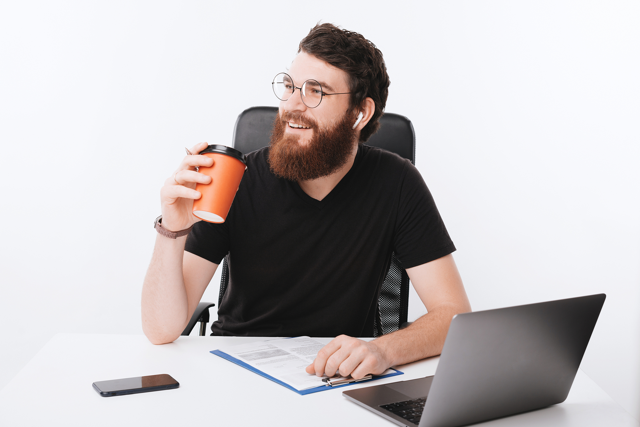 photo of young bearded freelancer, thinking at something while d