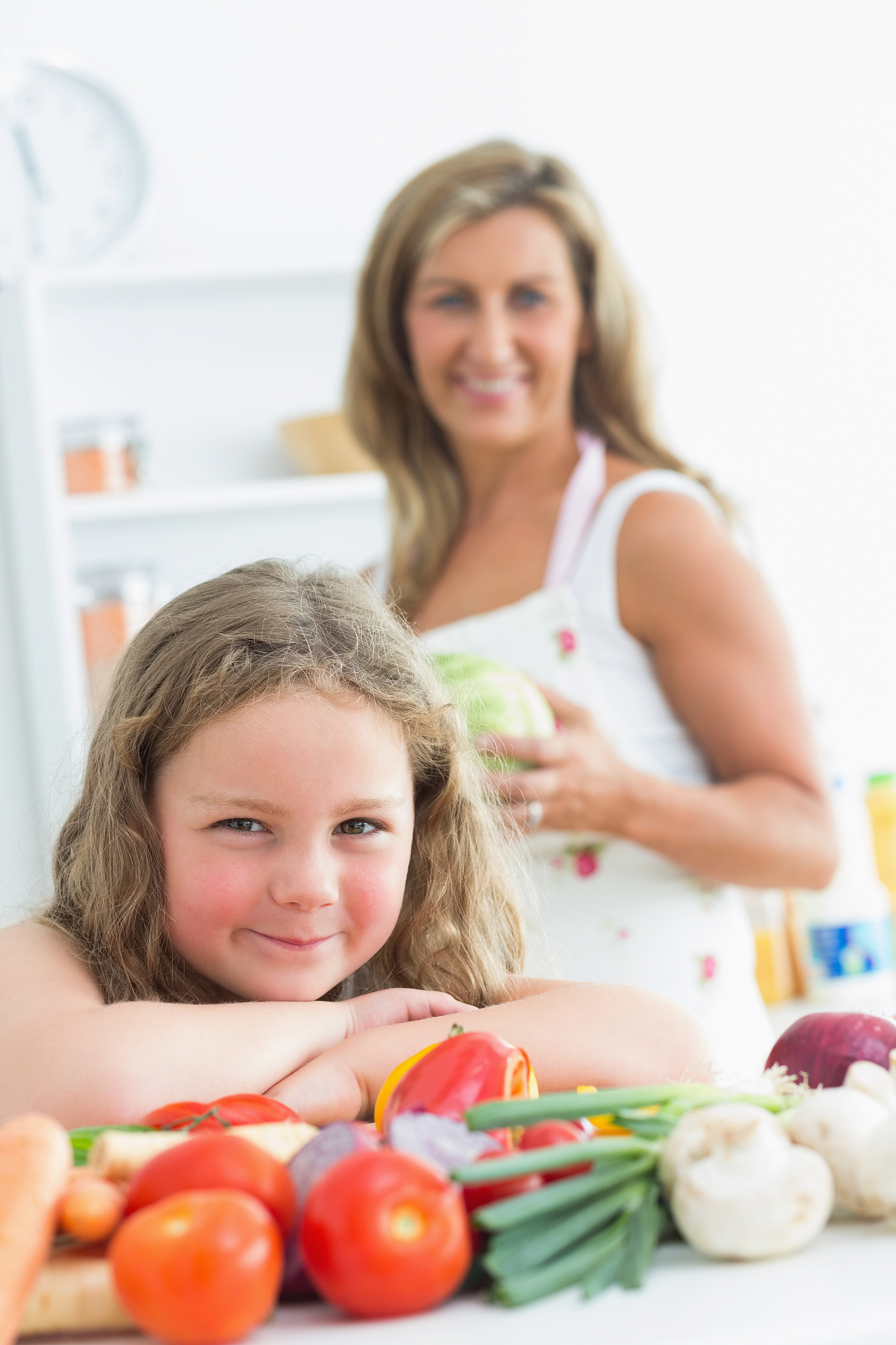 close up of daughter leaning on table full of vegetables