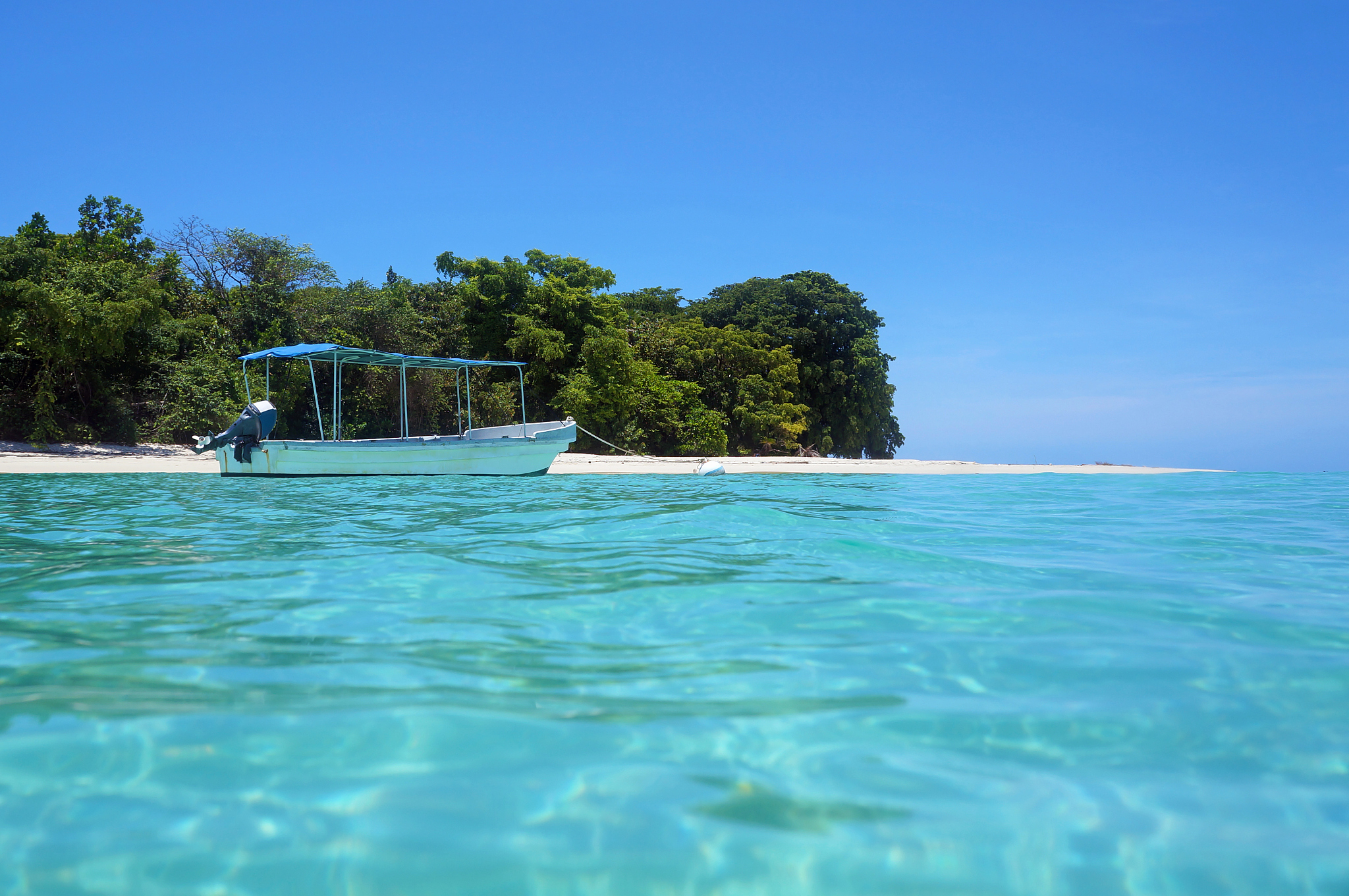 tropical island beach with a boat