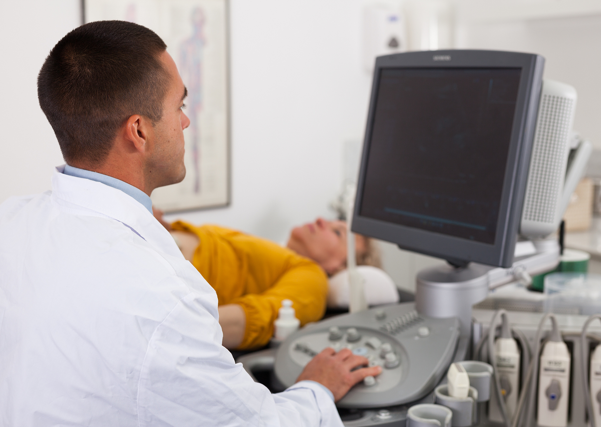 man sonographer examining female patient