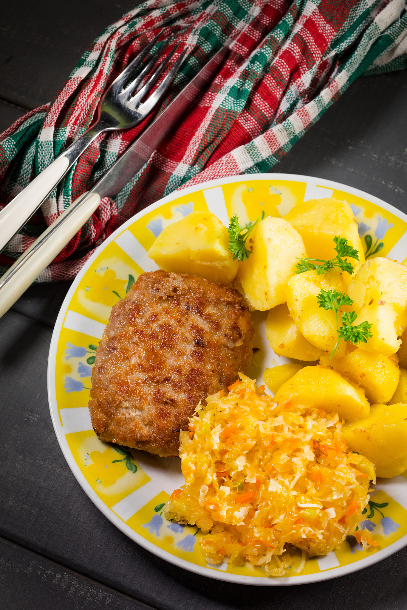 minced pork cutlet served with potatoes and sauerkraut salad.