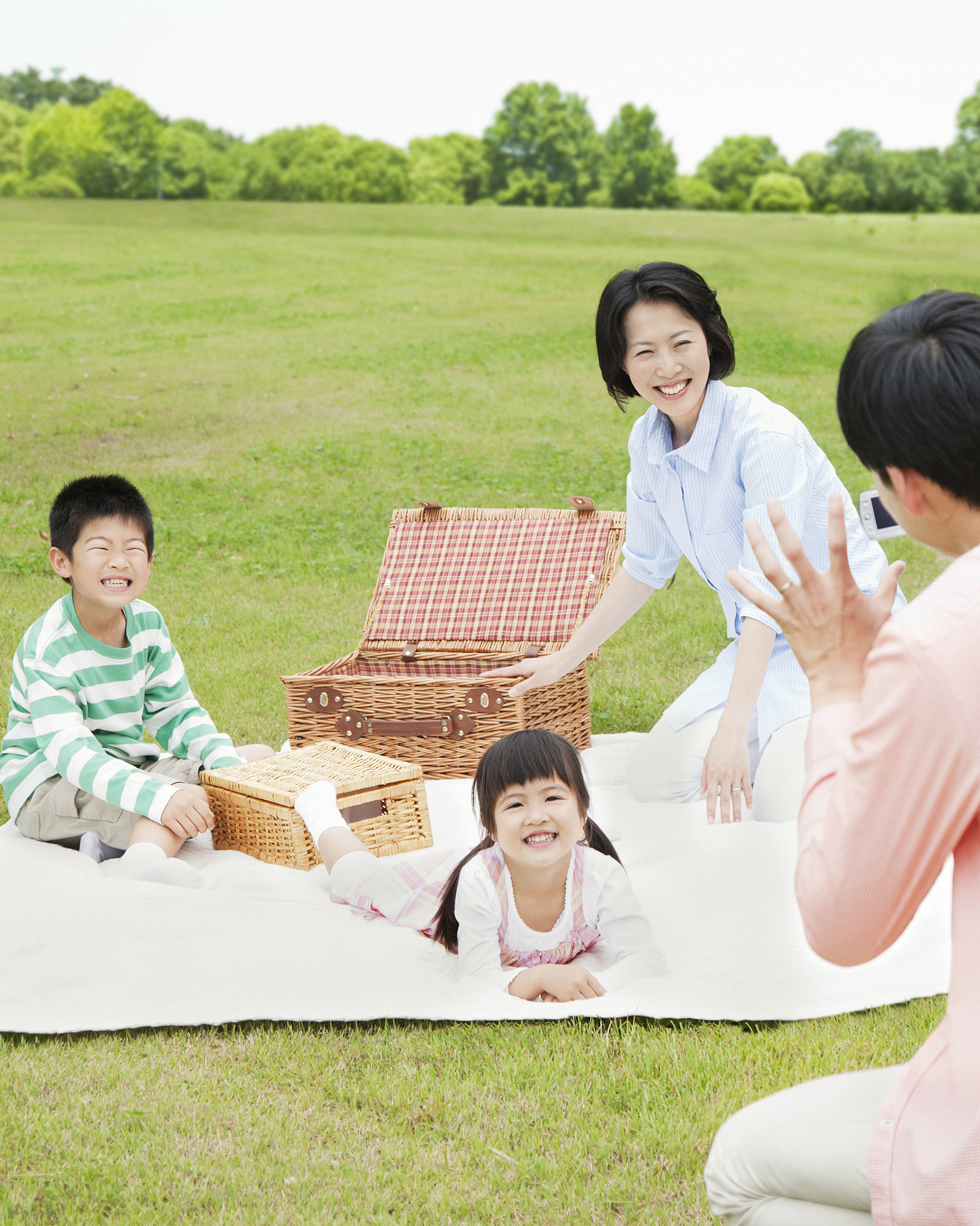 man filming his family at picnic