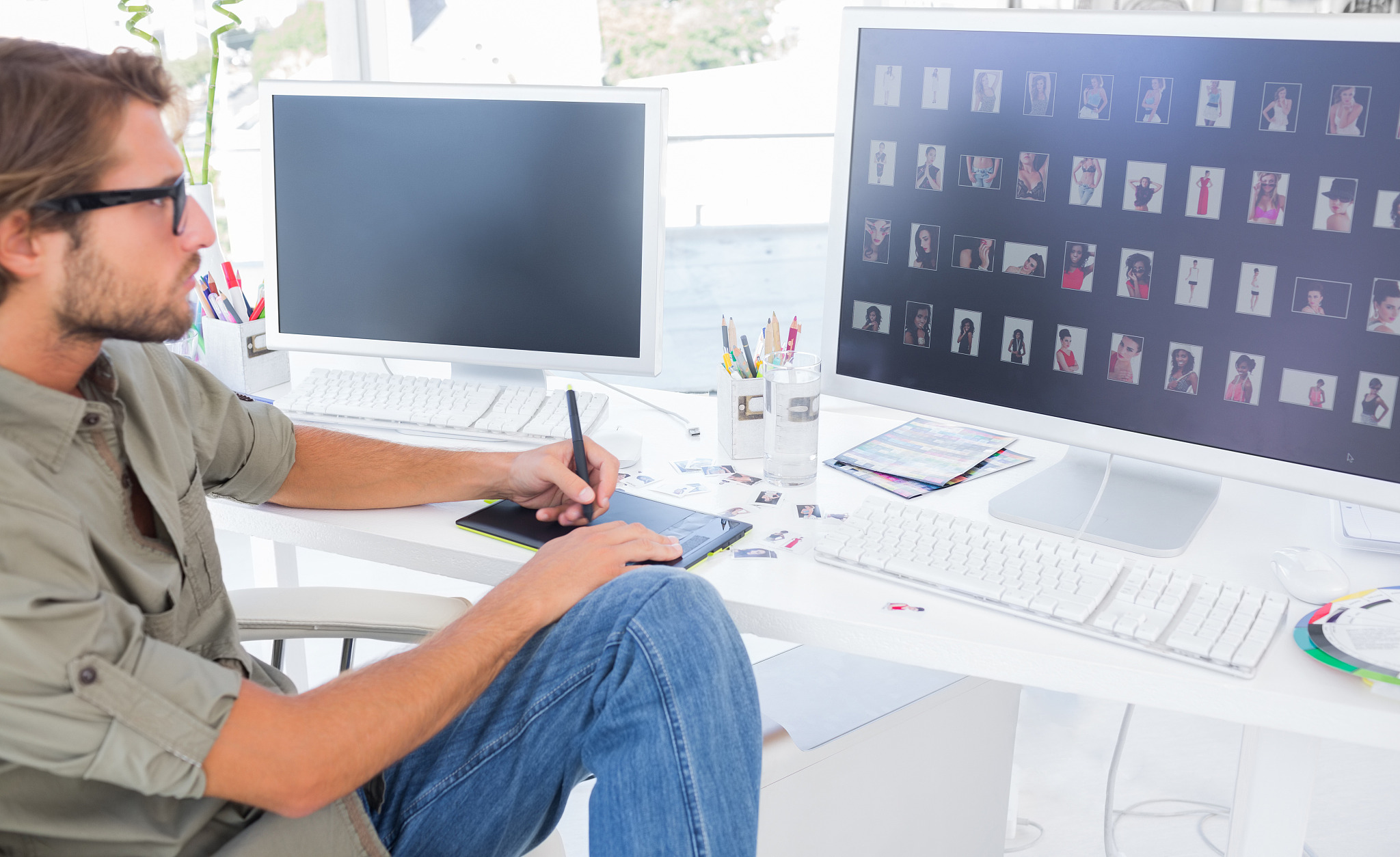 photo editor using digitizer to edit at desk in modern office