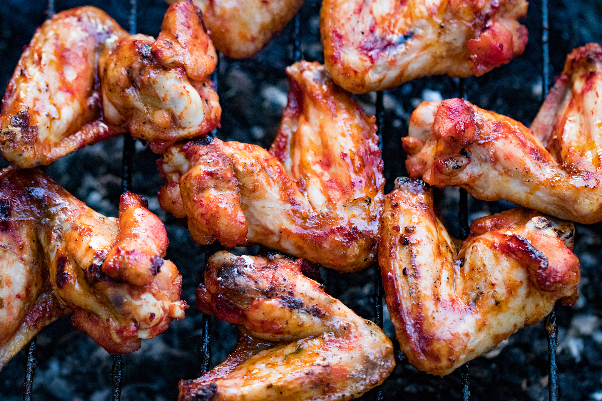 spicy marinated chicken wings grilling on a summer barbecue with