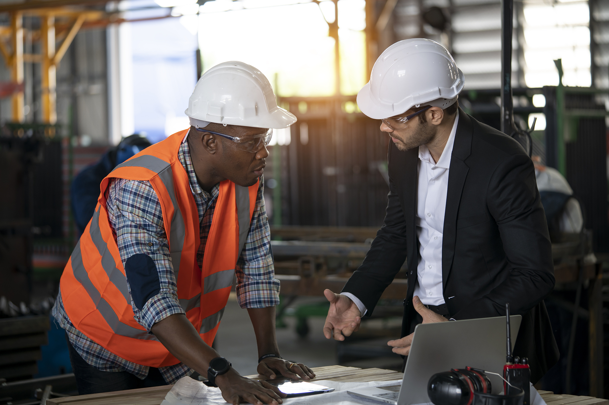 multi-ethnic workers talking in metal fabrication plant