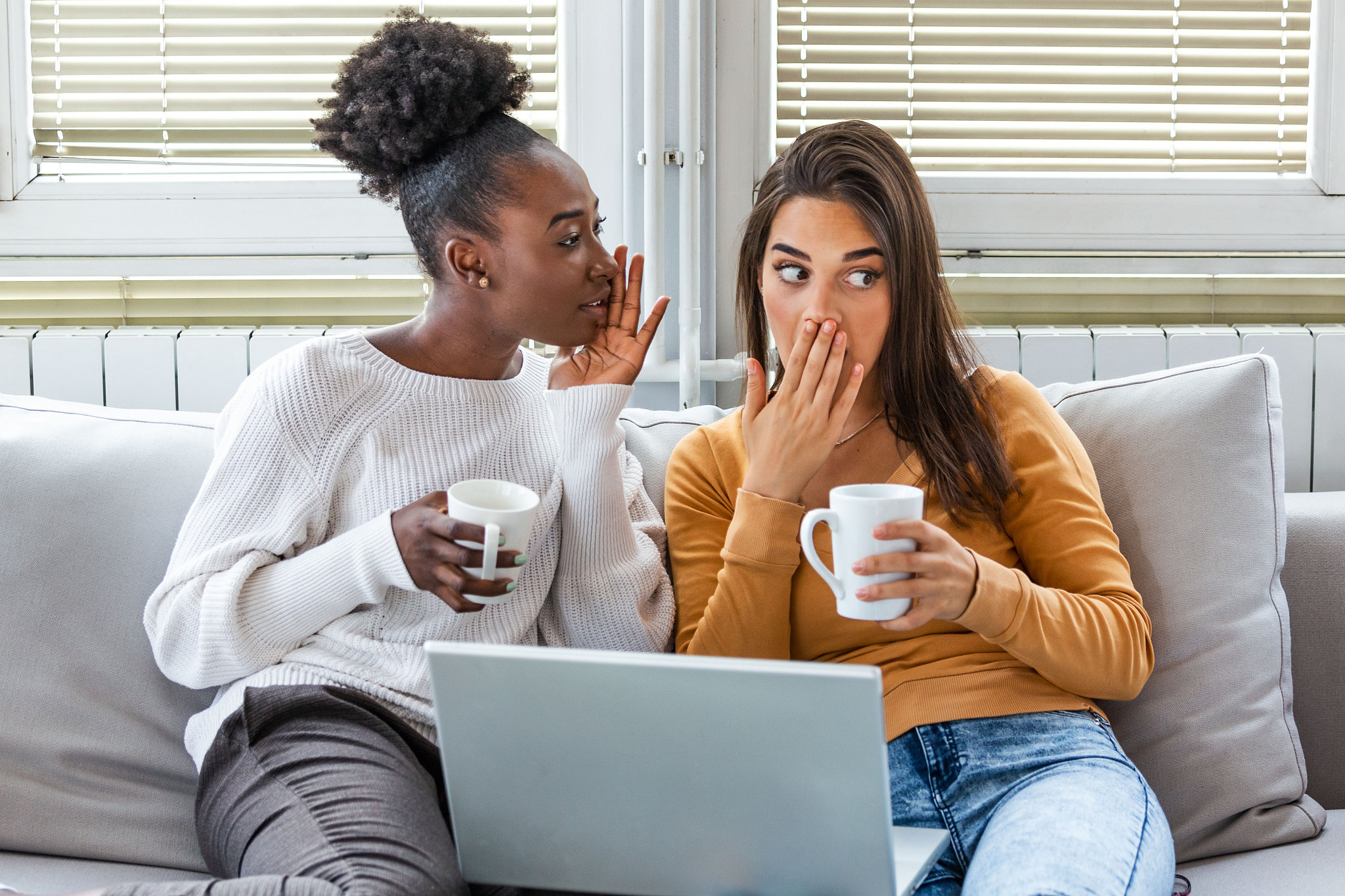diverse female friends sharing secrets. two women gossiping at h